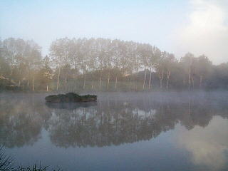 Morning mists over the lake by Corlay campsite